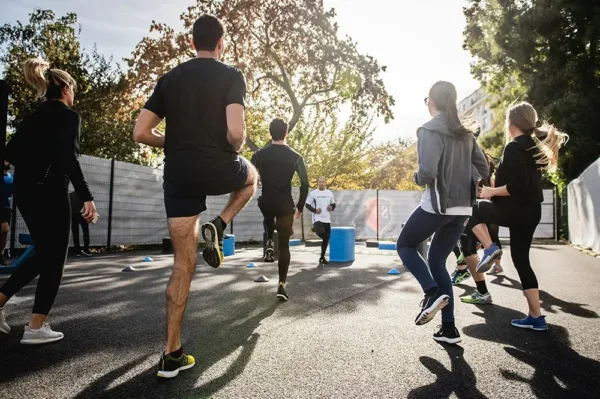 Group doing high-knee exercises outdoors in a fitness class